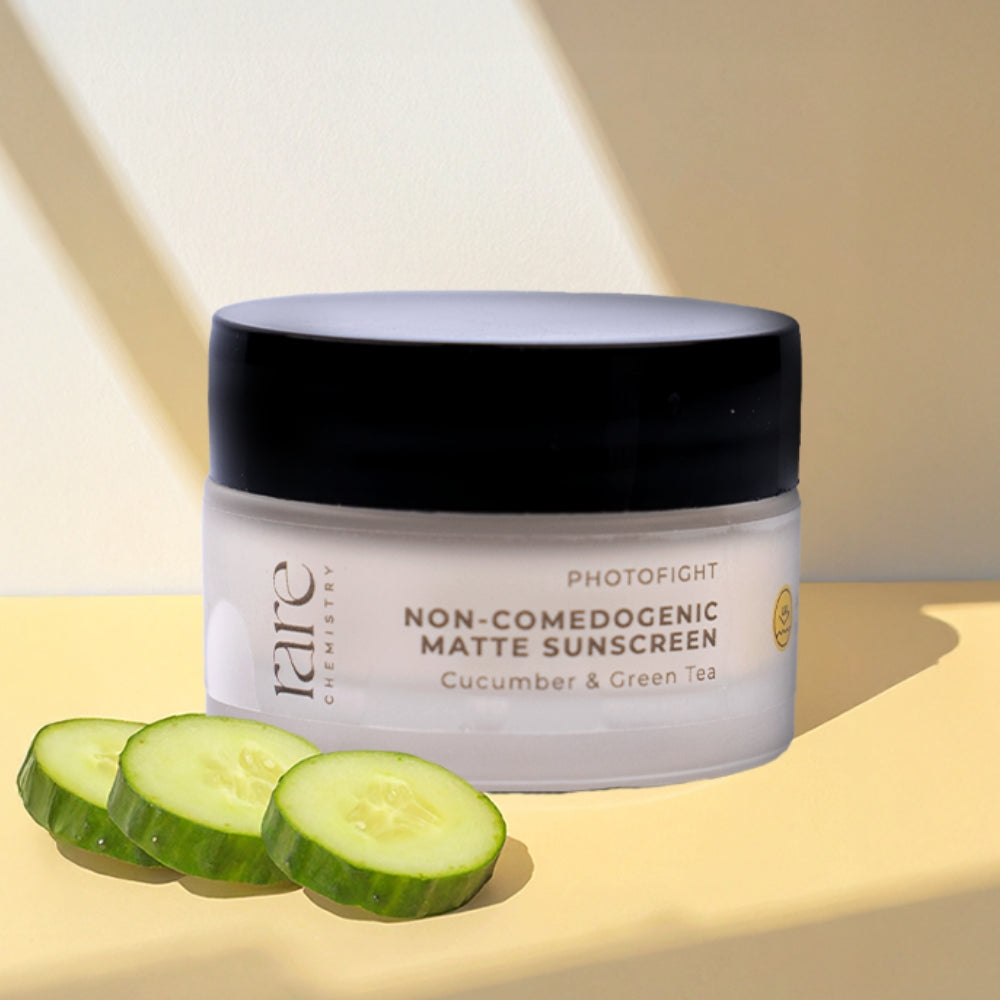 Jar of photofight non comedogenic matte sunscreen with cucumber slices on a light background