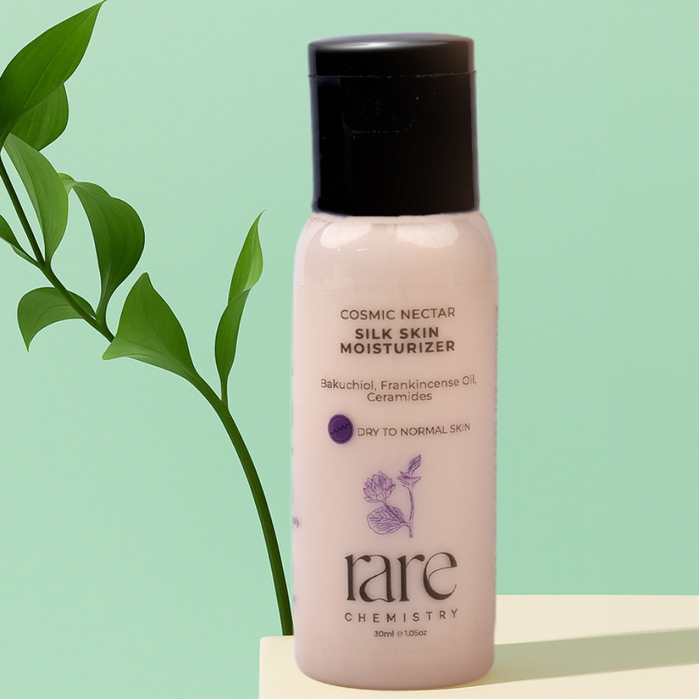 Cosmetic bottle labeled 'Cosmic Nectar Silk Skin Moisturizer' by 'rare CHEMISTRY' on a light green background with a plant.