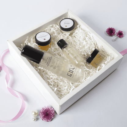 Set of skincare products in a white box with decorative flowers on a light background