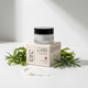 Luminous Day Eye Cream jar and box with green leaves on a white background