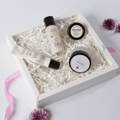 Set of skincare products in a white box with decorative flowers on a light background