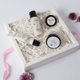 Set of skincare products in a white box with decorative flowers on a light background