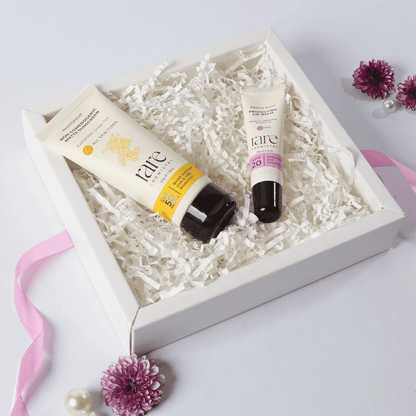 Two skincare products in a box with decorative flowers on a light background