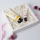 Two skincare products in a box with decorative flowers on a light background