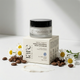 Jar of cream and its packaging with coffee beans and daisies on a light background