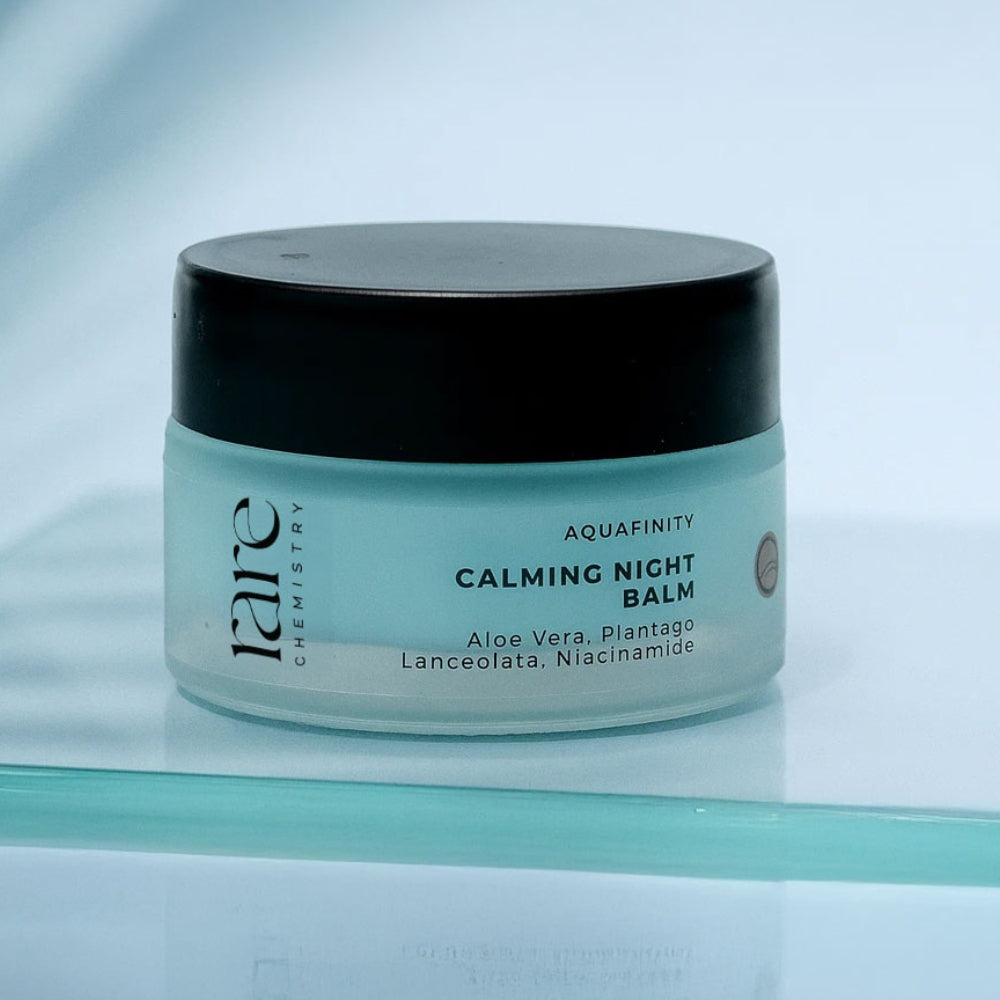 Jar of Aquafinity Calming Night Balm on a reflective surface with a light blue background