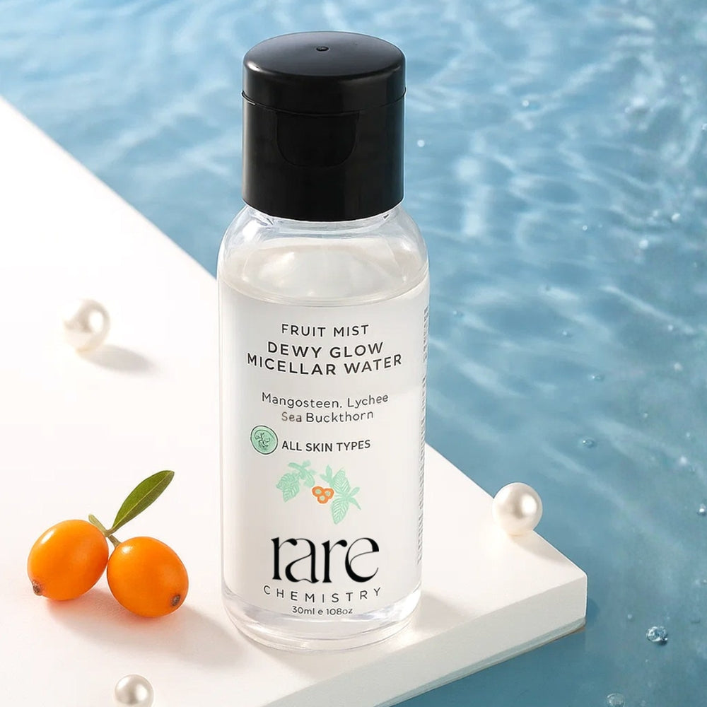 Bottle of 'rare chemistry' fruit mist dewy glow micellar water with ingredients displayed on a blue background.