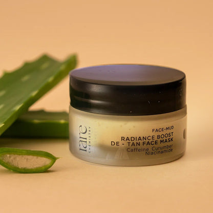 Jar of Radiance Boost De-Tan Face Mask with aloe vera leaves on a beige background