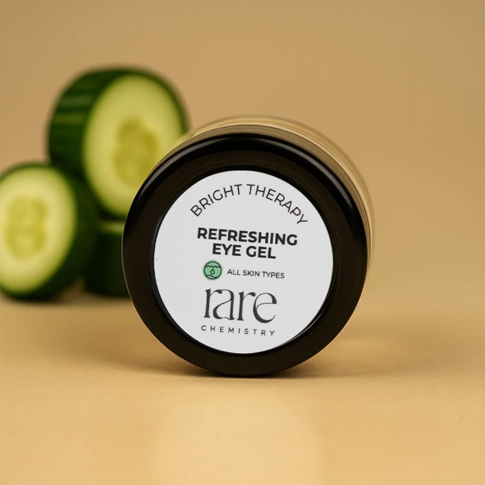 Jar of 'rare chemistry' refreshing eye gel with sliced cucumbers on a beige background