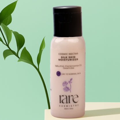 Cosmetic bottle labeled 'Cosmic Nectar Silk Skin Moisturizer' by 'rare CHEMISTRY' on a light green background with a plant.